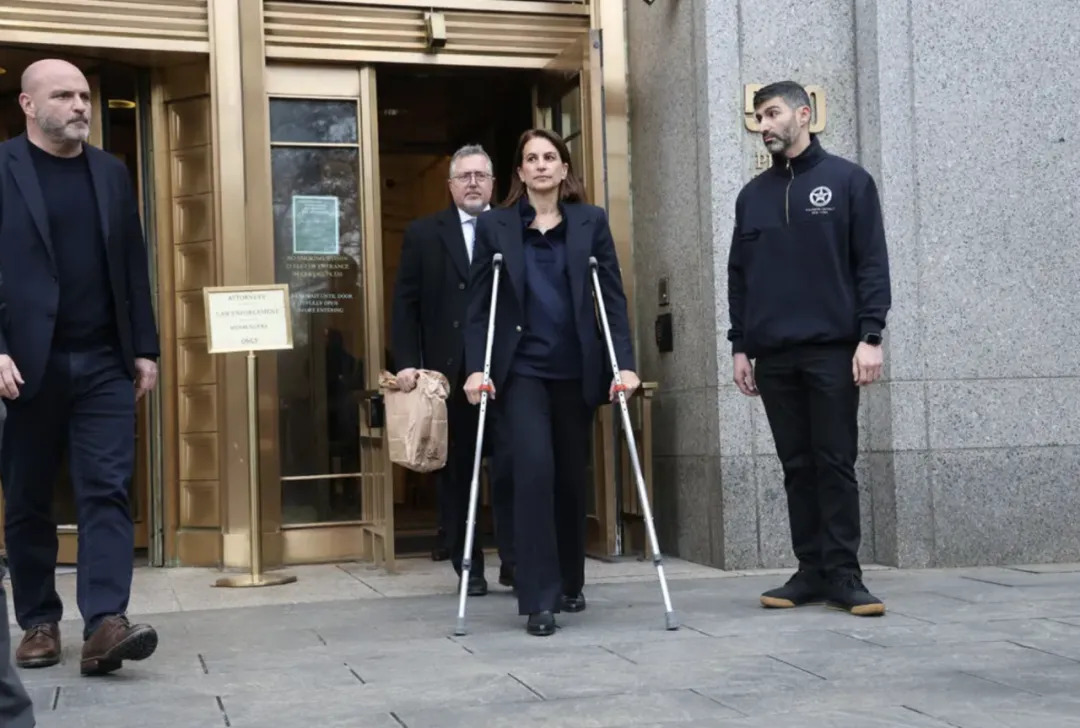 Karen walks in and out of Manhattan federal court on a crutch with her husband