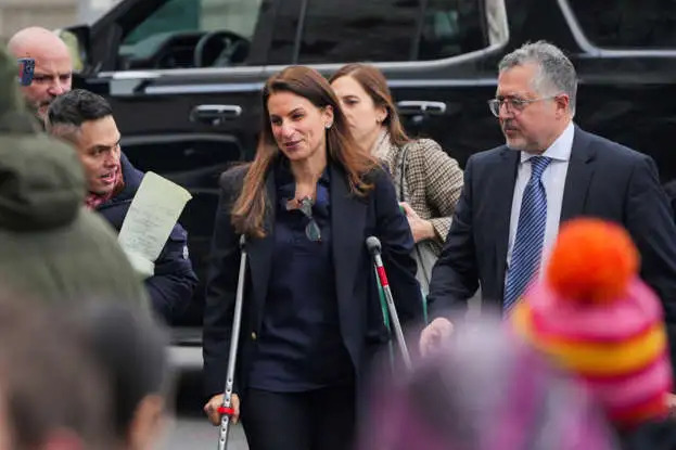 Karen walks in and out of Manhattan federal court on a crutch with her husband